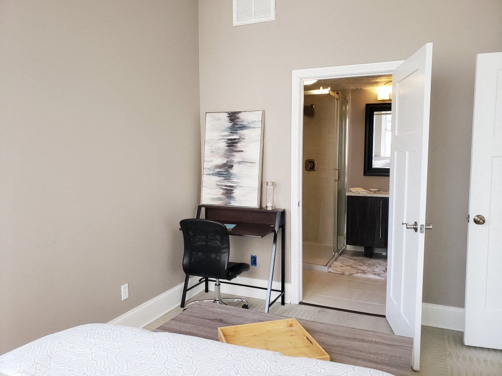 a bedroom with a bed and a desk with a chair