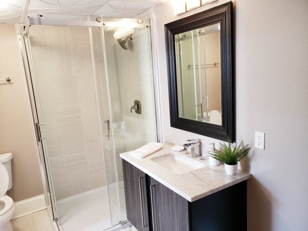 a bathroom with a shower and a sink and a mirror