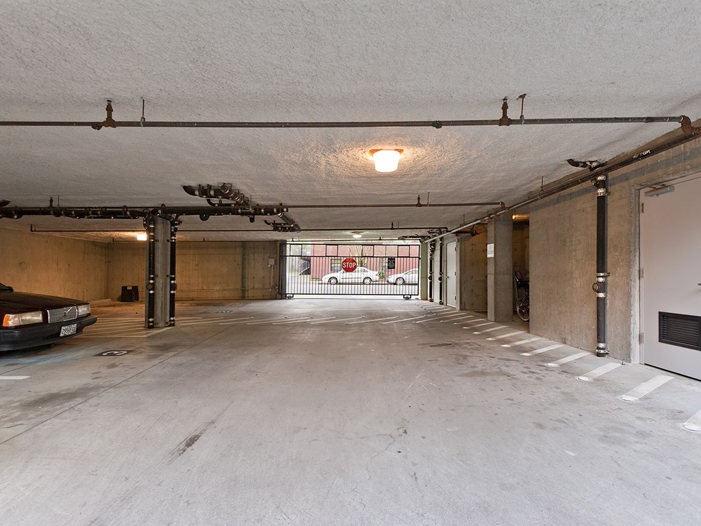 A large, empty parking garage with a concrete floor and white walls.