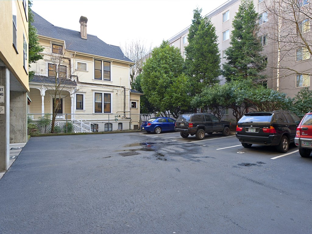 A parking lot with cars and a building in the background.