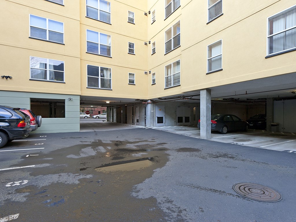 A parking lot in front of a yellow building with cars parked.
