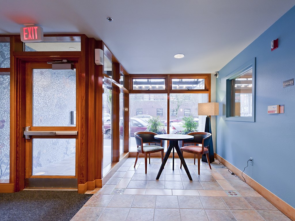 A view of a hallway with a table and chairs.