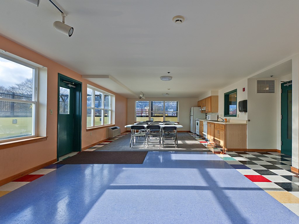 A room with a blue floor mat and a table with chairs.