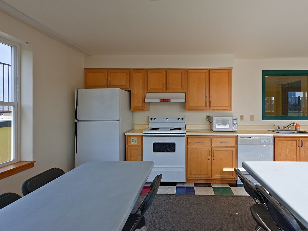 A kitchen with a refrigerator, oven, and microwave.