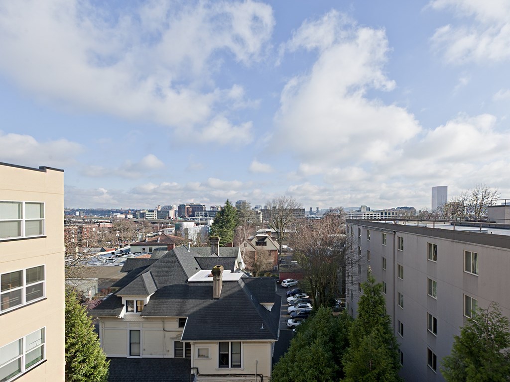A view from a high-rise building looking down at a residential area with houses and cars.