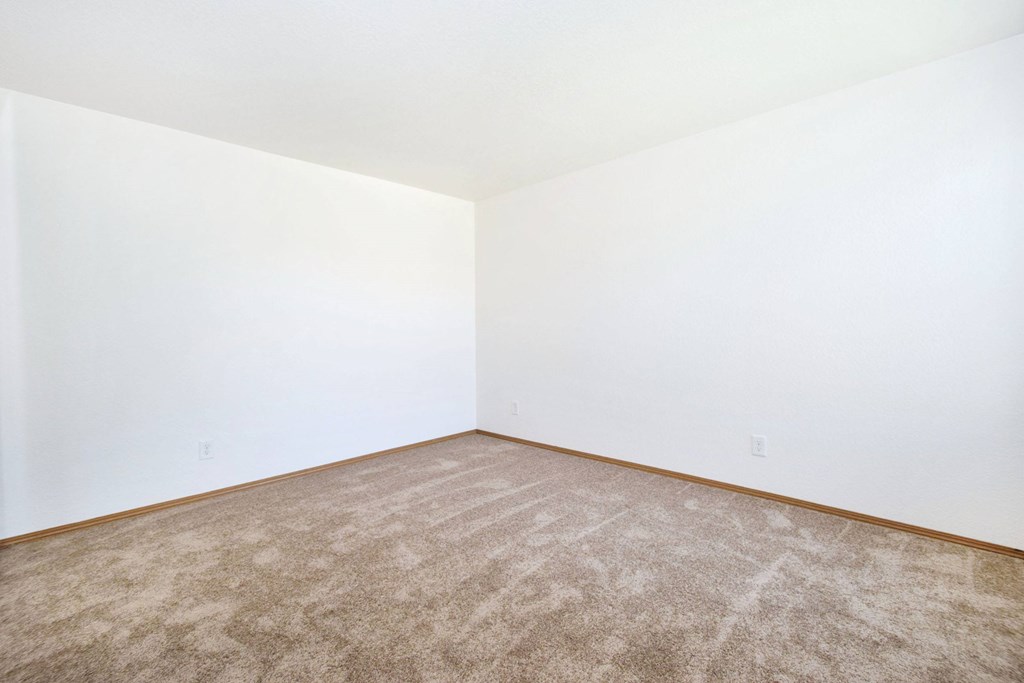 A room with a carpeted floor and white walls.