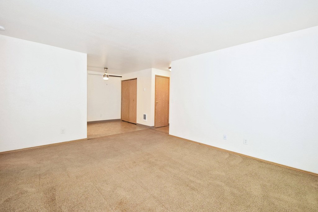 A room with carpeted floor and two doors.