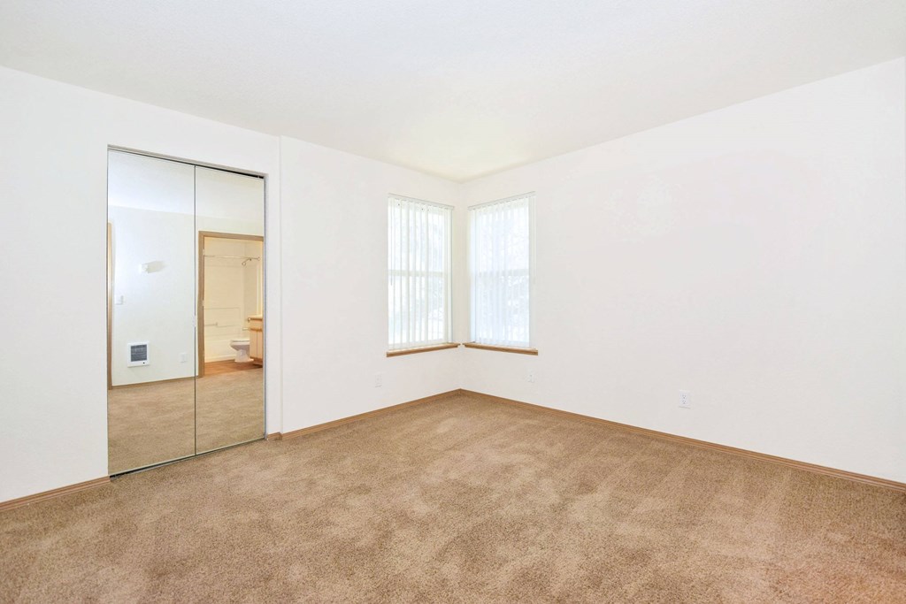 A room with a carpeted floor and a sliding glass door.
