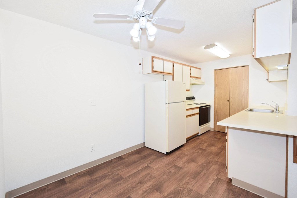 A kitchen with a refrigerator, microwave, and sink.