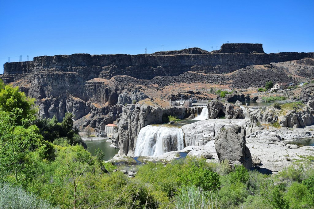 A waterfall flows into a lake surrounded by rocky cliffs.