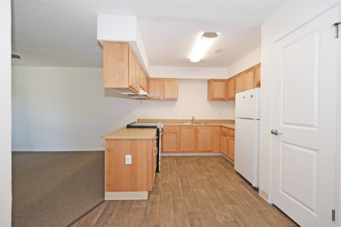 A kitchen with wooden cabinets and a white refrigerator.