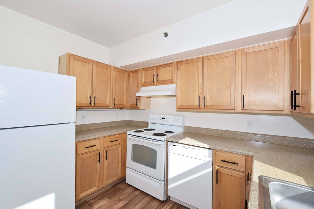 A kitchen with wooden cabinets and white appliances.