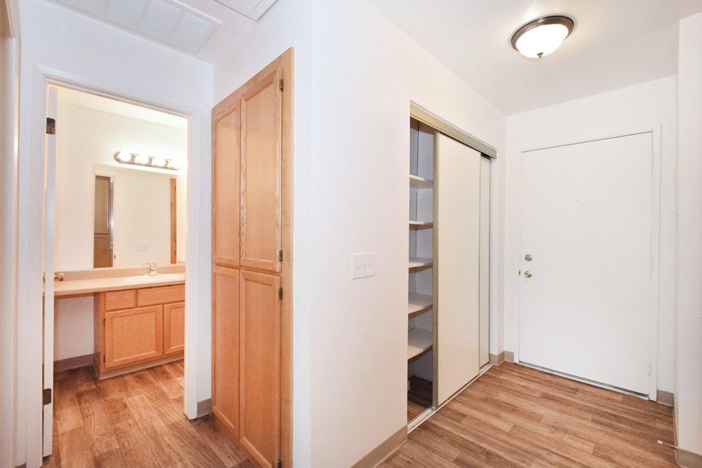 A white room with a wooden floor and a white door.
