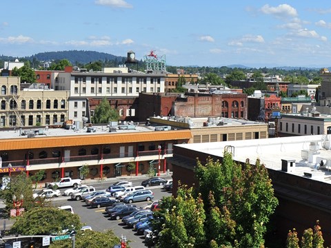 A parking lot with cars and a building with a red roof.