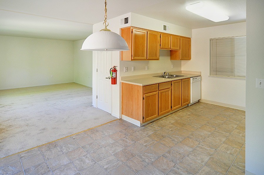 A kitchen with wooden cabinets and a tiled floor.