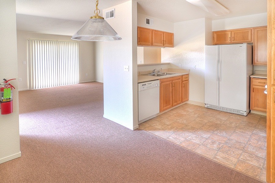 A kitchen with white appliances and wooden cabinets.