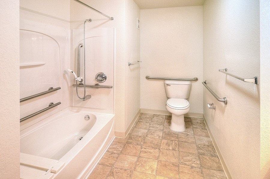 A white toilet in a bathroom with a tiled floor.
