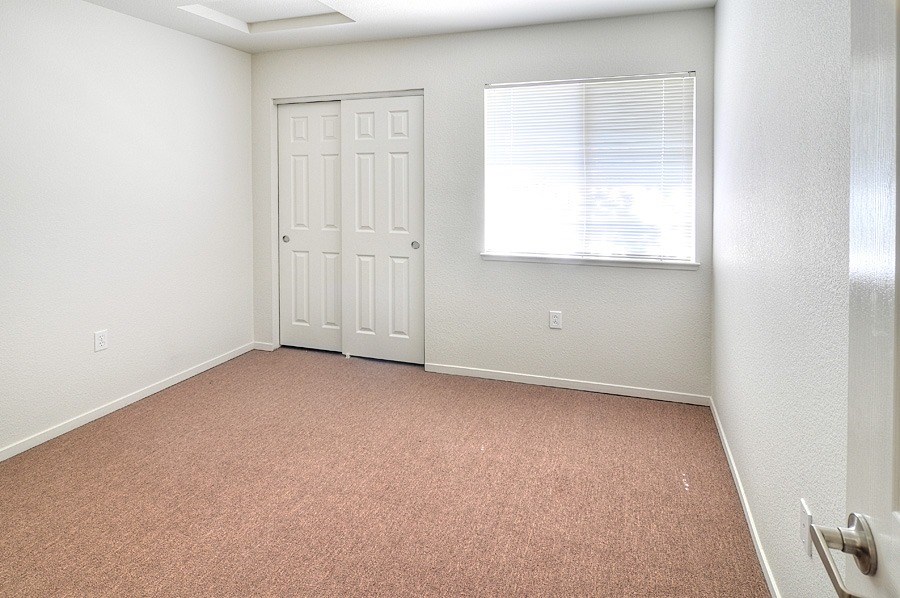 A room with a white door and a window with blinds.
