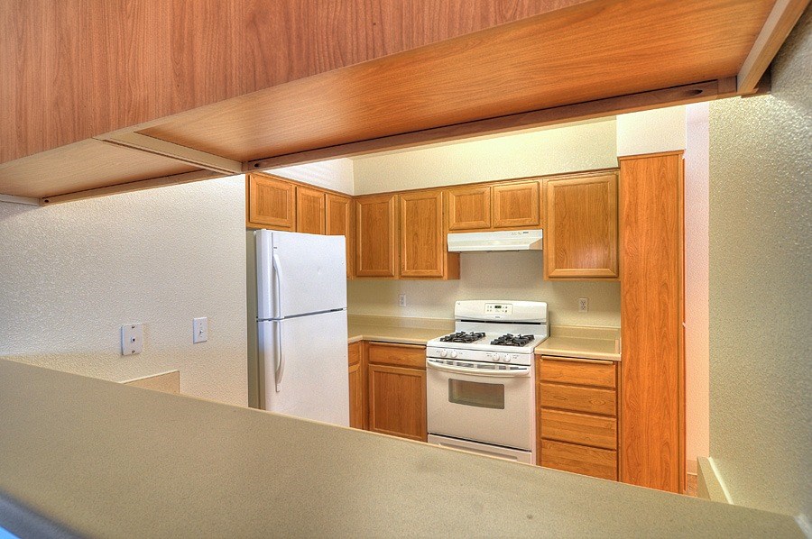 A kitchen with wooden cabinets and white appliances.