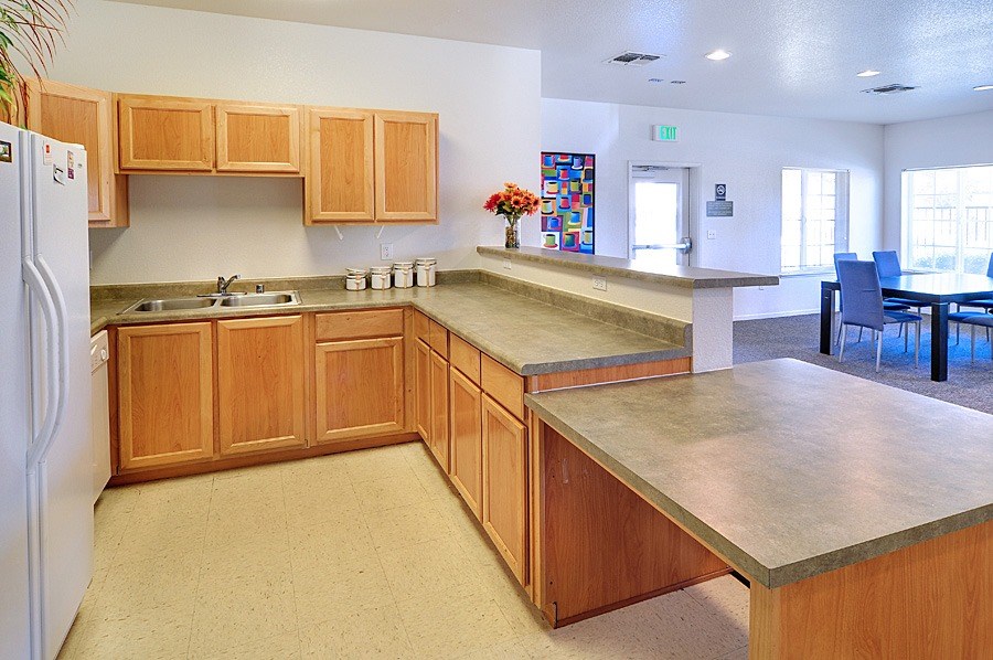 A kitchen with wooden cabinets and a white refrigerator.
