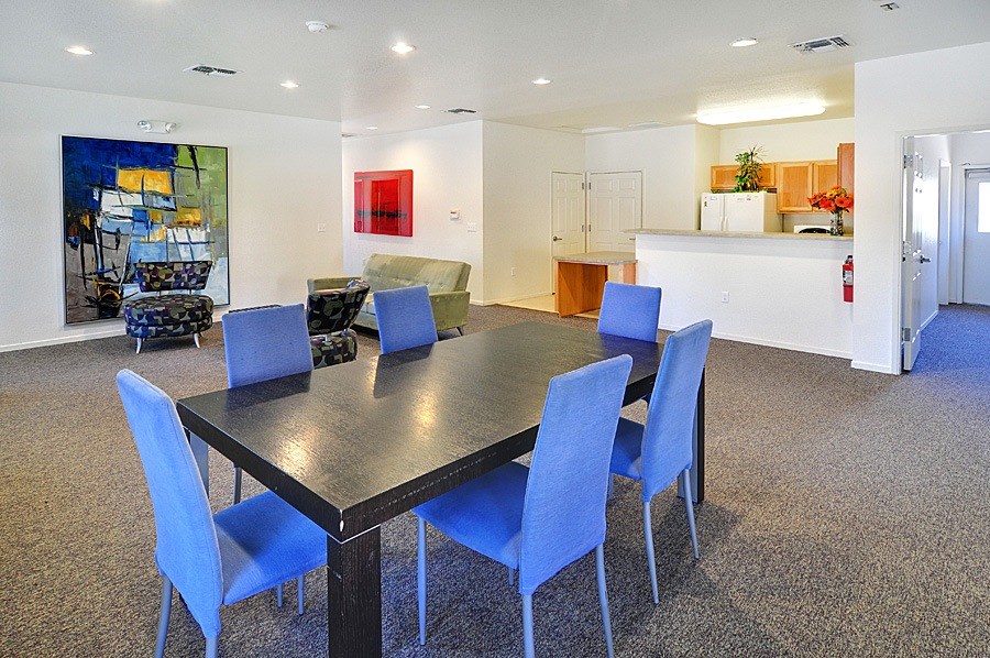 A black dining table with blue chairs in a room.