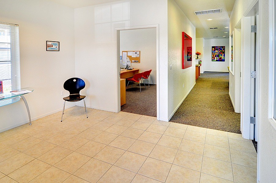 A room with a chair and a table in it.