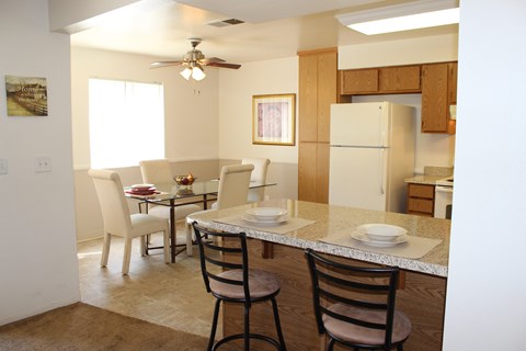 A kitchen with a table and chairs.