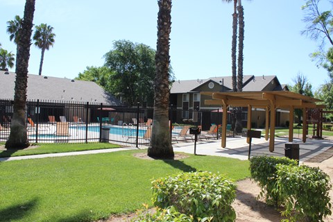 A pool surrounded by a fence and trees.