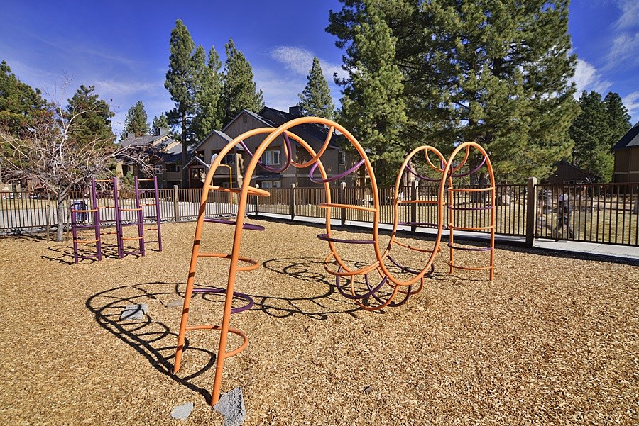 A playground with orange swings and a purple slide.