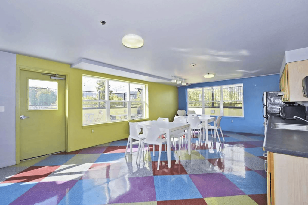 A room with a yellow door and a table with chairs.