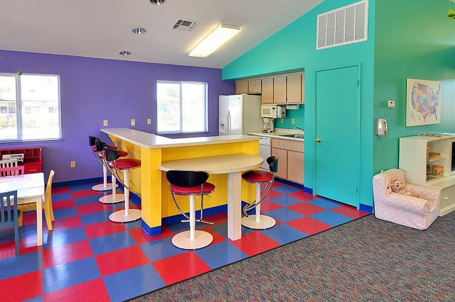A kitchen with a yellow table and chairs.