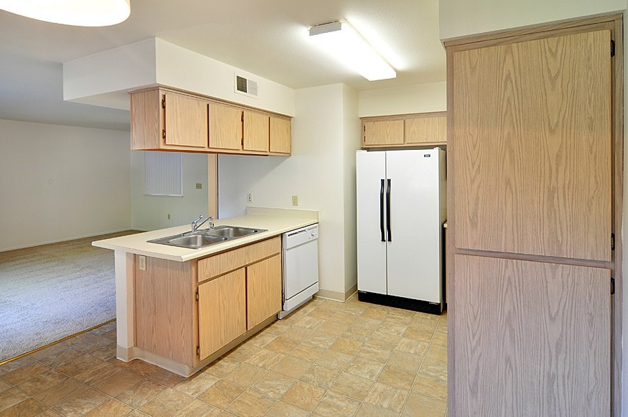 A kitchen with a sink, stove, and refrigerator.