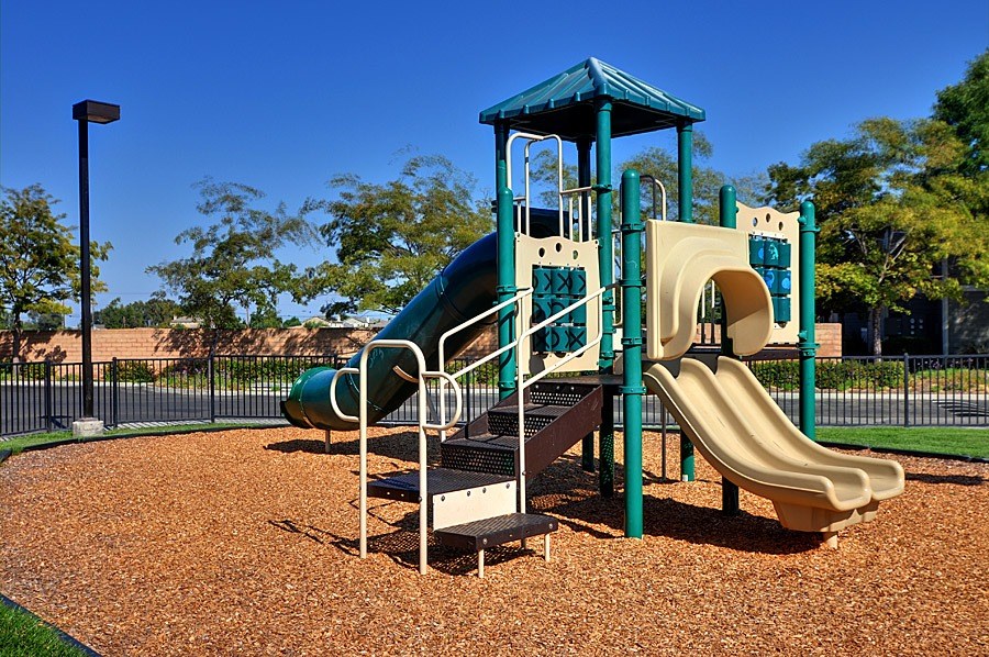 A playground with a green slide and a blue roof.