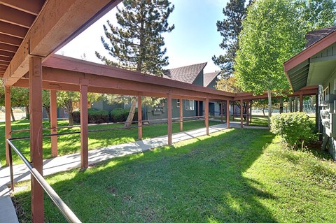 A wooden covered walkway with a metal railing.
