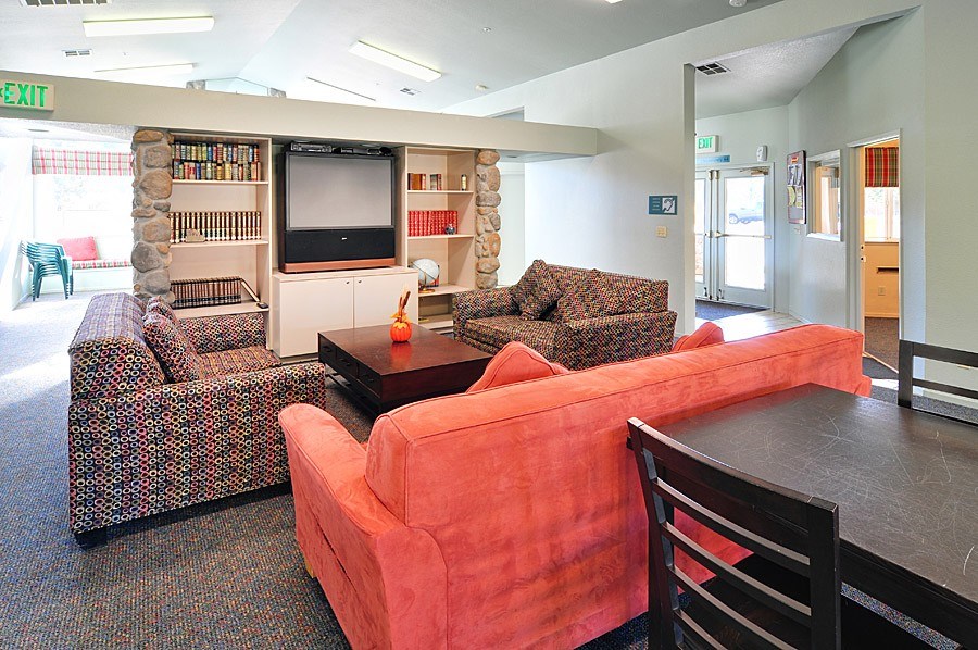 A living room with a couch, chair, and television.