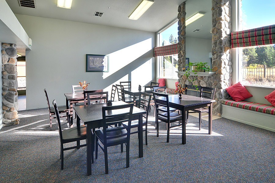 A dining room with a table and chairs.