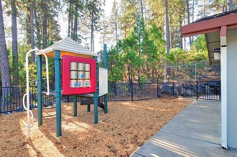 A playground with a red and blue structure and a slide.