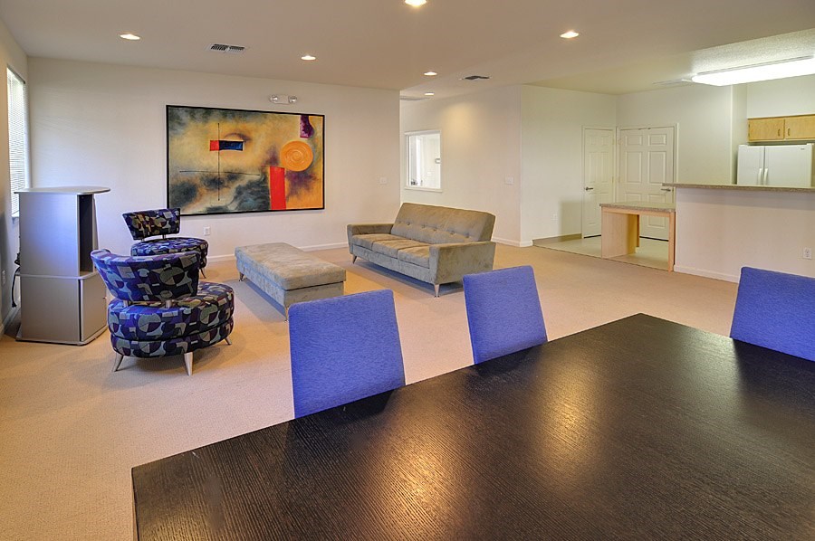 A living room with a brown table and blue chairs.