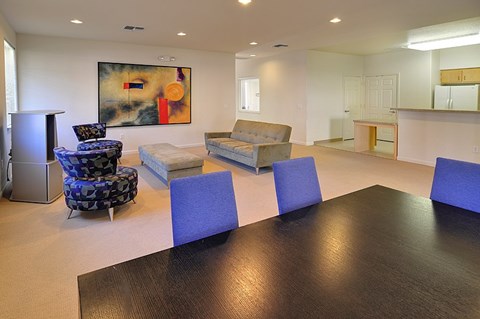 A living room with a brown table and blue chairs.