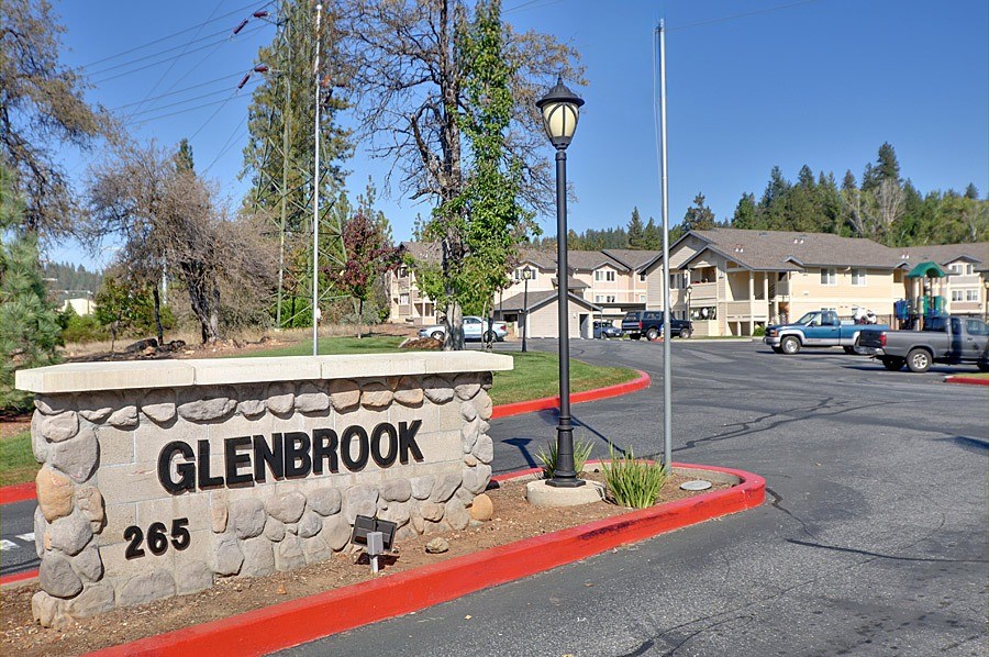 A street sign for Glenbrook with a stone base and a red border.
