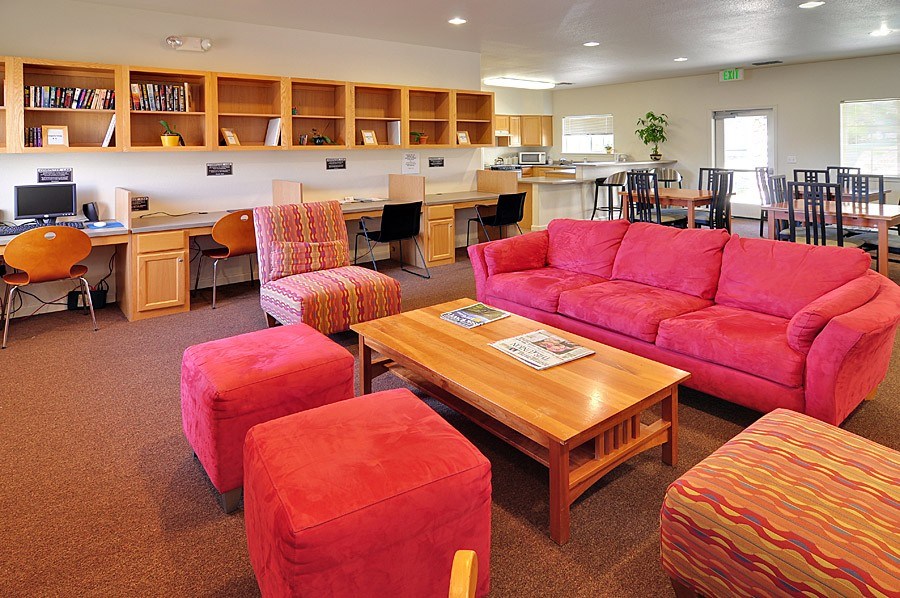 A room with a red couch and ottoman.