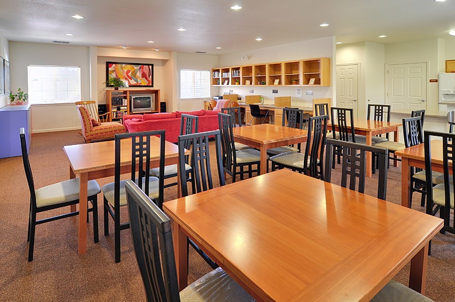 A large wooden dining table surrounded by chairs in a room.