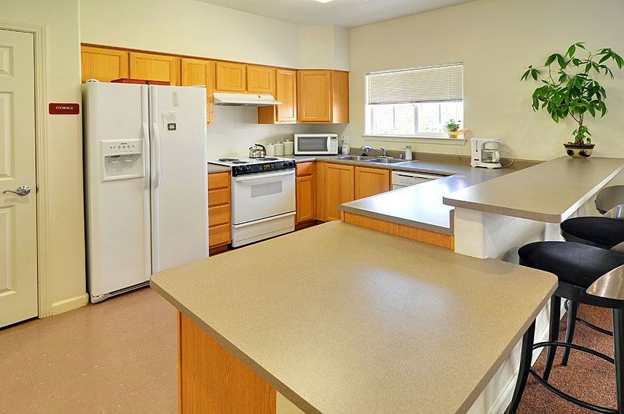 A kitchen with a white refrigerator and wooden cabinets.