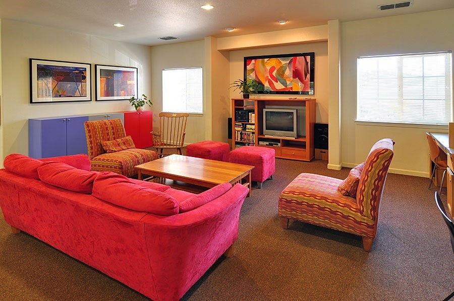 A living room with a red couch and a television.