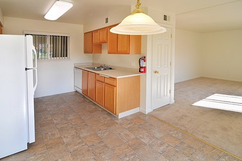 A kitchen with wooden cabinets and a white refrigerator.