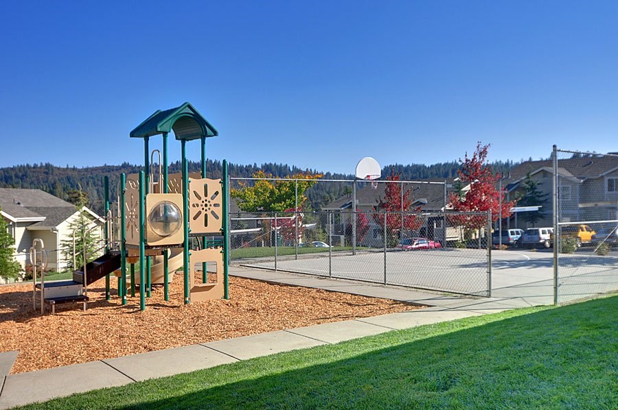 A playground with a green roof and a basketball hoop.