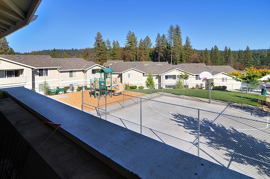 A playground with a swing set and a basketball court in a residential area.