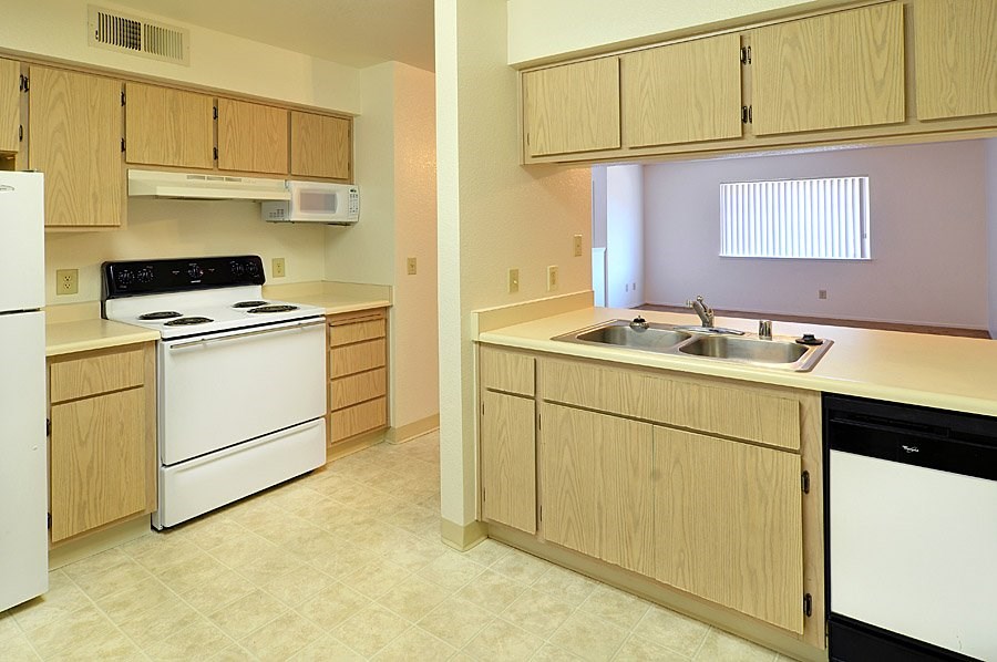 A kitchen with a white fridge and a black stove top.