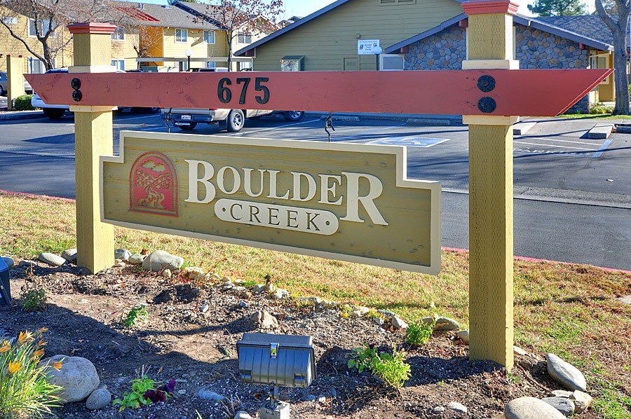 A sign for Boulder Creek with a red and white striped top.