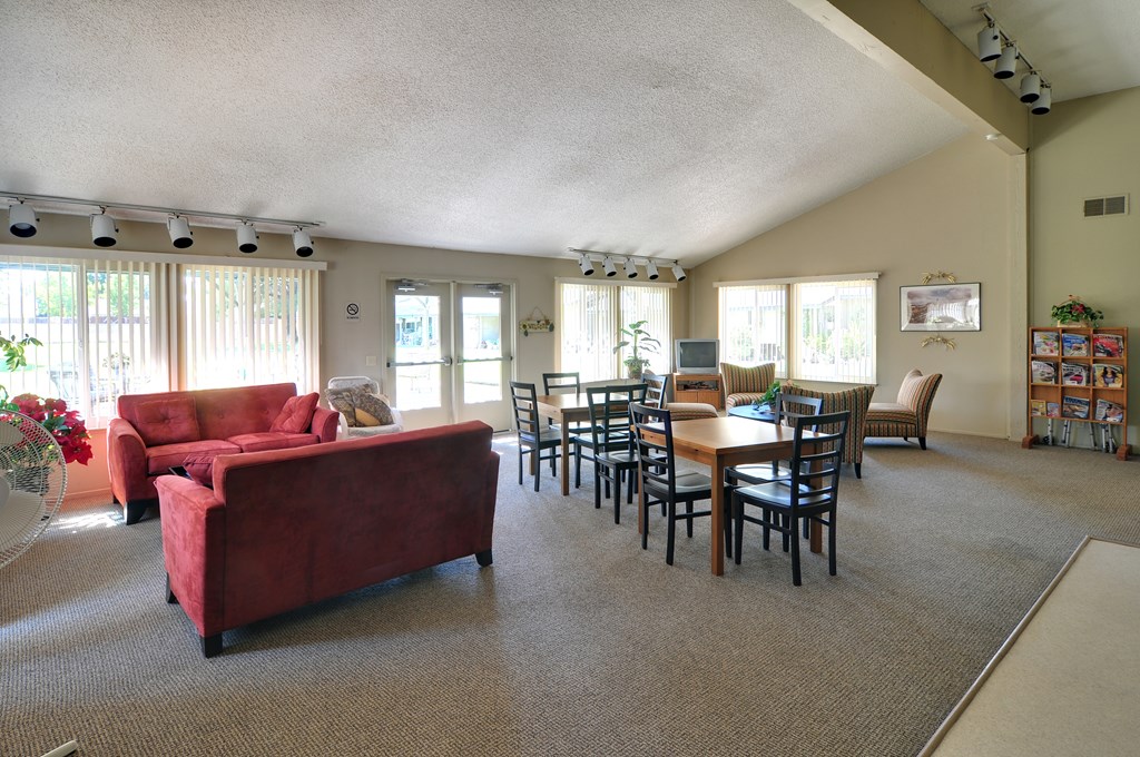 A living room with a red couch and a dining table.